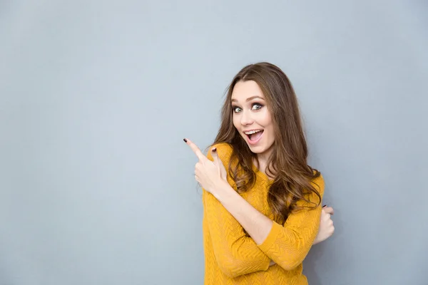 Cheerful woman pointing finger away — Stock Photo, Image