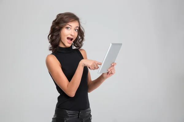 Feliz mujer asombrada apuntando en la tableta — Foto de Stock