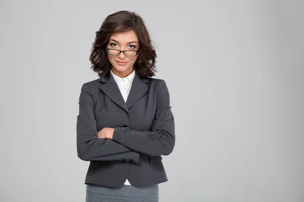 Confident pretty businesswoman in glasses standing with crossed arms — Stock Photo, Image