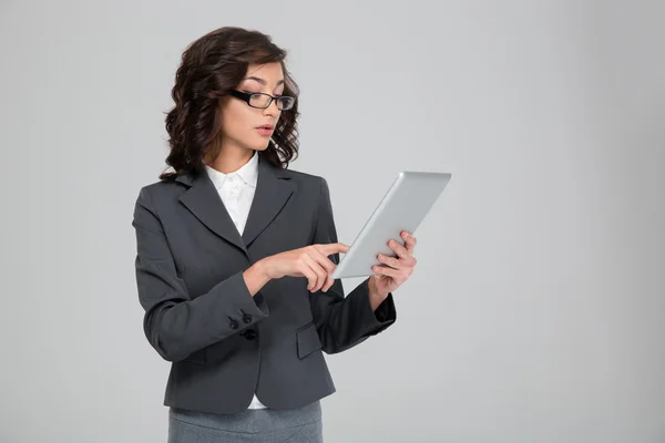 Mujer de negocios joven y concentrada usando tableta — Foto de Stock