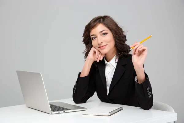 Unga vackra kvinnan arbetar med laptop och skriva på anteckningsboken — Stockfoto