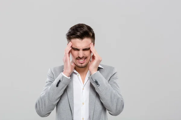 Young man with hands on temples suffering from headache — Stock Photo, Image
