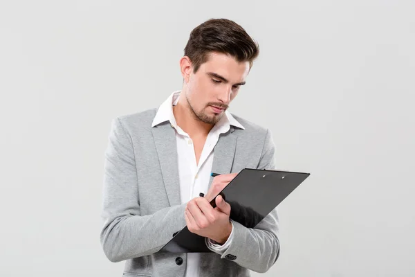 Joven emprendedor escribiendo en portapapeles —  Fotos de Stock