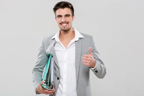 Homem bonito feliz segurando ligantes e mostrando polegares para cima — Fotografia de Stock