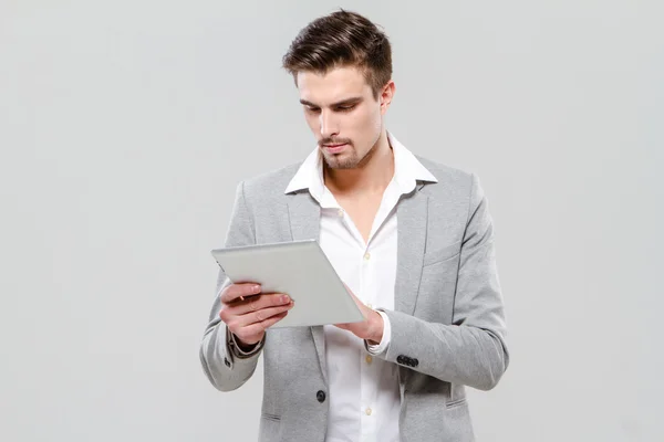 Jovem empresário concentrado usando tablet — Fotografia de Stock