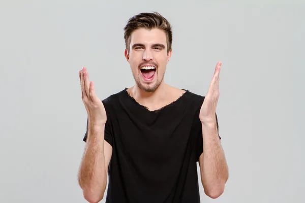 Portrait of young man screaming with hands up — Stock Photo, Image