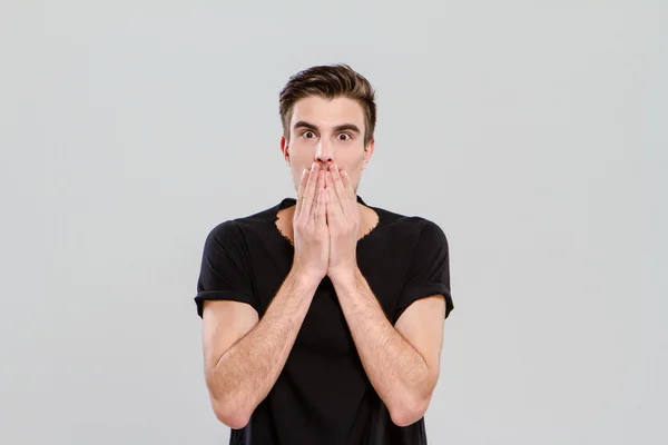 Young man surprised and closed mouth with hands — Stock Photo, Image