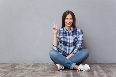 Katta oturan ve zafer işaret gösteren bir kadın