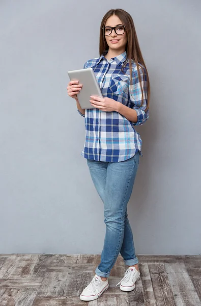 Retrato de comprimento total de bela menina inteligente segurando tablet — Fotografia de Stock