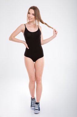 Full length portrait of cheerful happy girl playing with hair