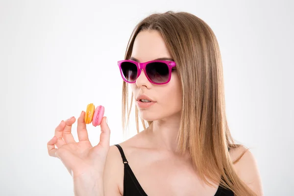 Beautiful sensual young girl in sunglasses looking on macarons — Stock fotografie