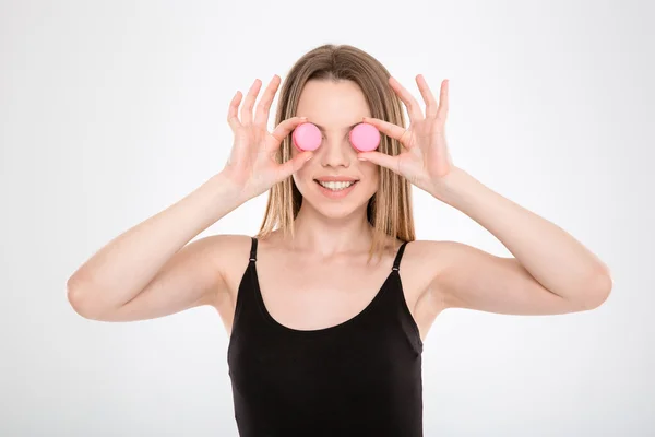 Pretty young woman put macarons instead of eyes — Zdjęcie stockowe