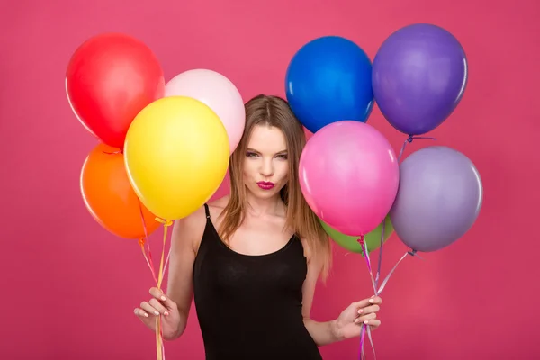 Attractive flirty woman with colorful balloons planning surprise — Stock fotografie