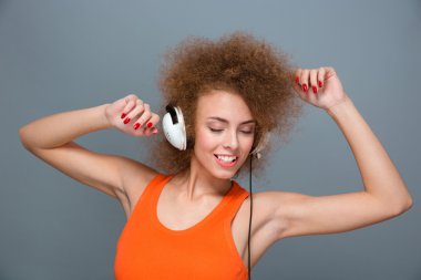 Positive smiling beautiful girl listening to music and dancing 