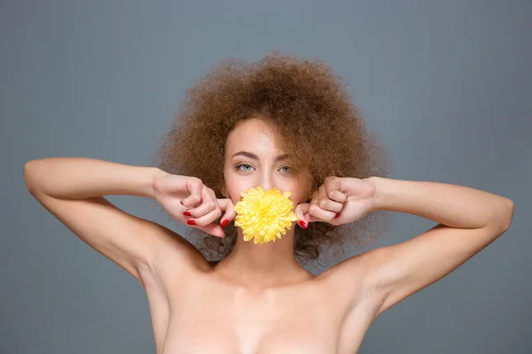 Portrait of beautiful young woman with yellow flower in mouth — Stock Photo, Image