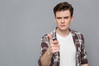 Portrait of a serious young man pointing on you