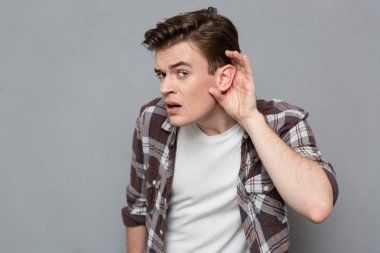 Curious young male trying to listen rumors
