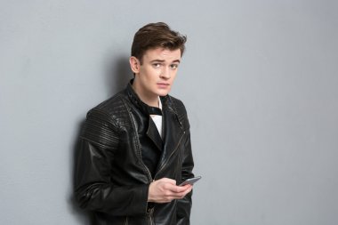 Smartphone tutan deri ceketli genç adam