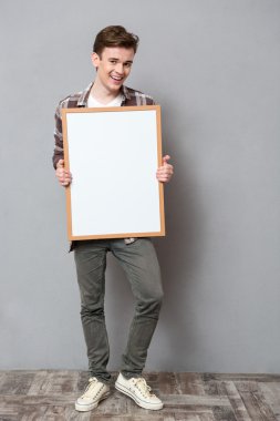 Pano tutan gülümseyen erkek öğrenci