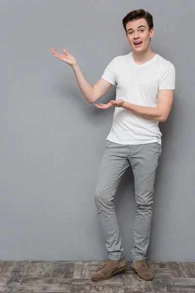 Attractive young man holding copyspace on palms — Stock Fotó