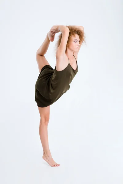 Kvinnliga ballerina med lockigt hår sträcker benet — Stockfoto