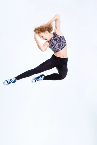 점프 하는 곱슬 머리를 가진 재미 있는 여자 — 스톡 사진