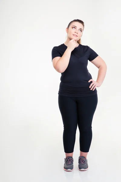 Fundersam fet kvinna i sportkläder tittar upp — Stockfoto