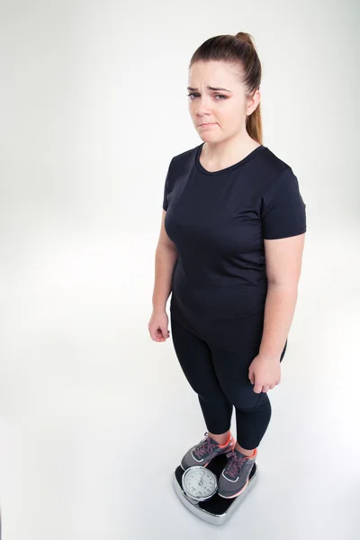 Sorgliga fet kvinna stående på väger maskinen — Stockfoto