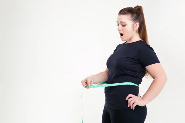 Толстая женщина измеряет свою талию — стоковое фото