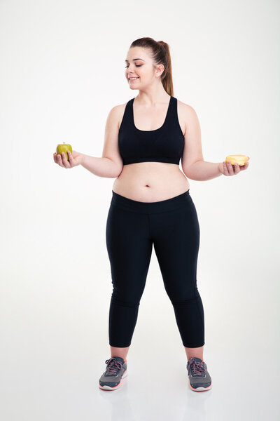 Fat woman choosing between donut and apple