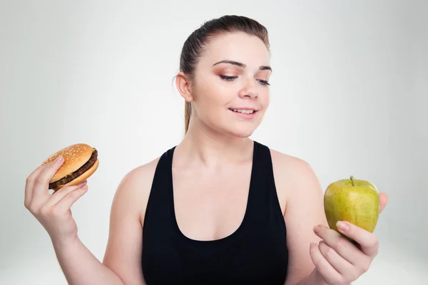 Mujer gorda elegir entre hamburguesa o manzana — Foto de Stock