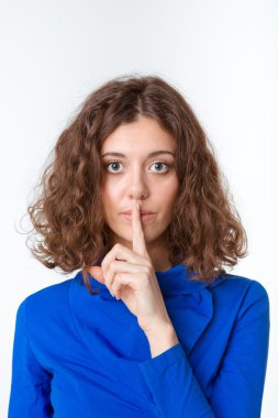 Genç kadın gösteren parmak dudaklar üzerinde