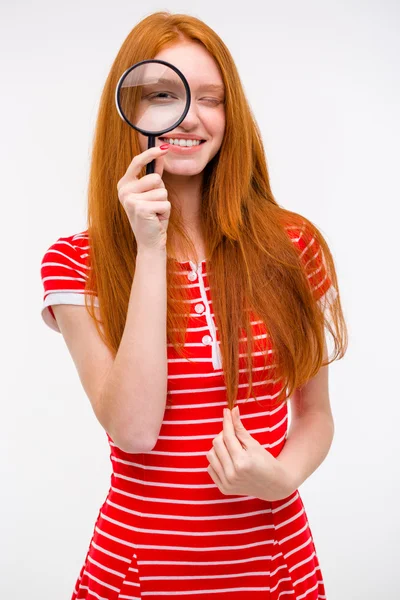 Divertente ragazza gioiosa guardando attraverso lente di ingrandimento — Foto Stock