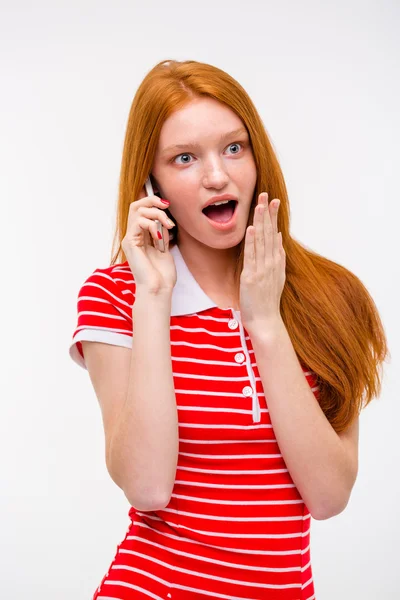 Amazed excited redhead woman talking on mobile phone — Zdjęcie stockowe