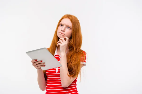 Nachdenklich schöne junge Frau denkt und hält Tablette — Stockfoto