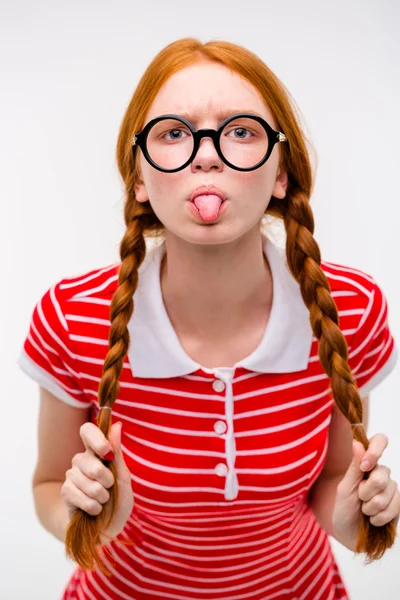 Funny amusing girl in round glasses showing tongue — Zdjęcie stockowe