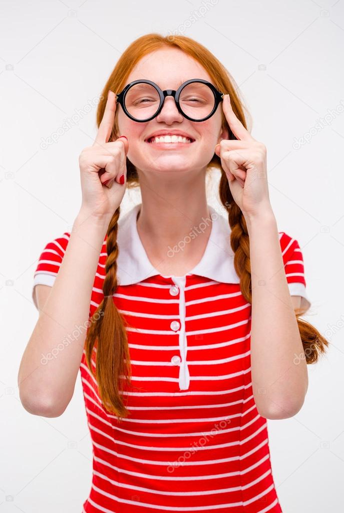 Cheerful funny young female fixing glasses and smiling 