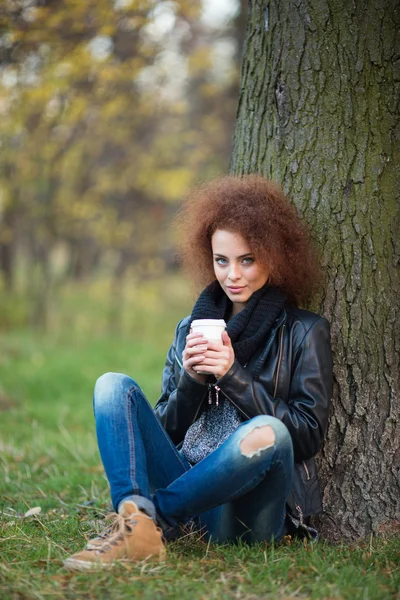 Mujer bebiendo café bajo el árbol —  Fotos de Stock