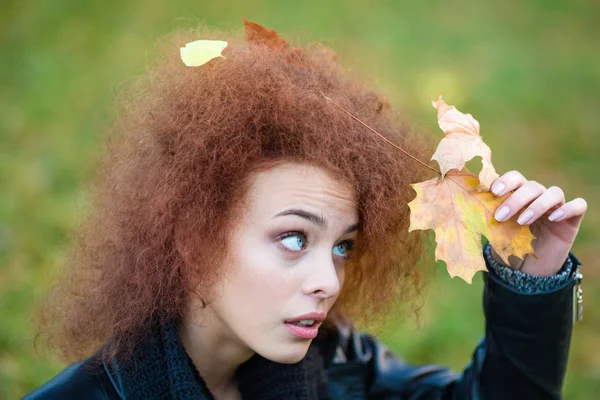 Vrouw opzoeken op Bladeren in haar krullend haar — Stockfoto