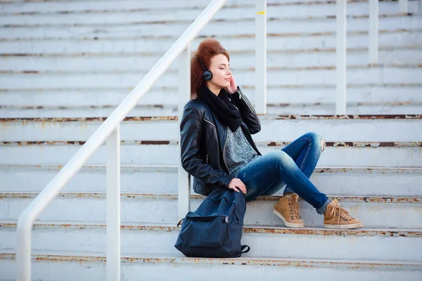 Mujer escuchando música en escaleras al aire libre — Foto de Stock