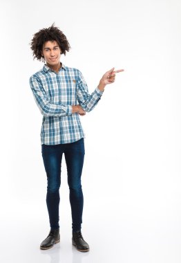 Kıvırcık saçlı işaret parmağı uzakta Afro Amerikalı adam gülümseyen