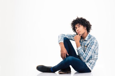 Pensive afro american man sitting on the floor