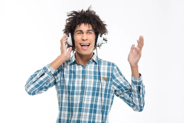 Afro american man with curly hair listening music in headphones — Stock fotografie