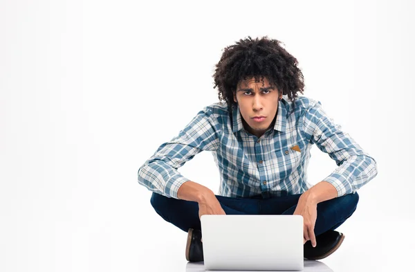 Triste uomo afro americano seduto sul pavimento con il computer portatile — Foto Stock