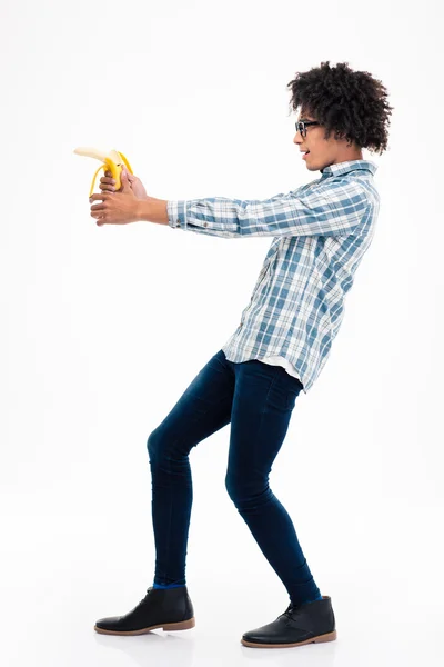 Funny afro american man aiming from banana — Stockfoto