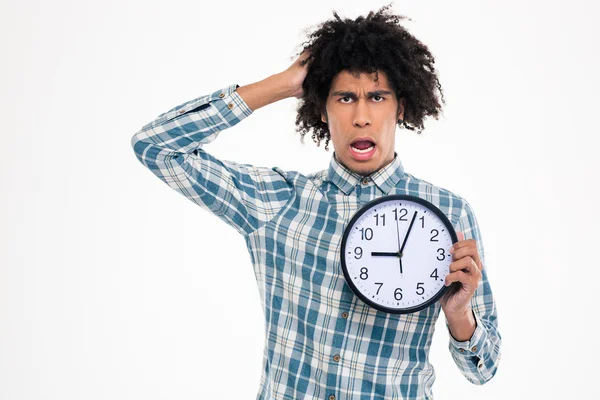 Shocked afro american man holding wall clock — Stockfoto