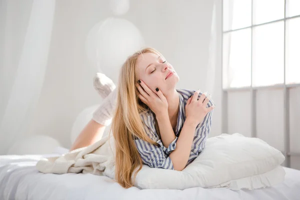 Sensual tender blonde woman lying in white bed — Stok fotoğraf