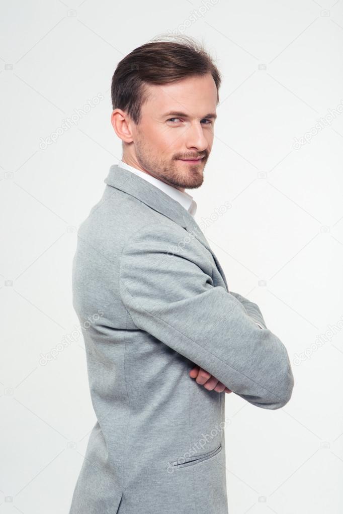 Happy businessman standing with arms folded 