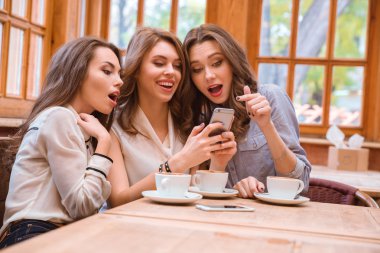 Neşeli üç kadın Smartphone kullanarak