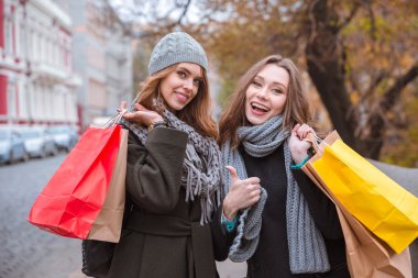 Açık havada duran ve alışveriş torbaları tutan kız 